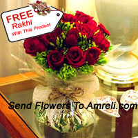 12 Red Roses With Some Ferns In A Vase And A Free Rakhi