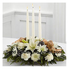 Celebrates the holiday season with winter grace and style. White lilies, carnations and roses create an exquisite display. Surrounding three white taper candles, this holiday centerpiece will add light and love to their seasonal celebration. (Please Note That We Reserve The Right To Substitute Any Product With A Suitable Product Of Equal Value In Case Of Non-Availability Of A Certain Product)