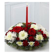 This Centerpiece spreads joy and good tidings during this seasonal time of generosity and togetherness. Rich red roses, red mini carnations, white Gerberas,  simple taper candle for a colourful and eye-catching floral display that will make your table complete this season. A wonderful way to spruce up your festivities or brighten the season for your family or friends! (Please Note That We Reserve The Right To Substitute Any Product With A Suitable Product Of Equal Value In Case Of Non-Availability Of A Certain Product)
